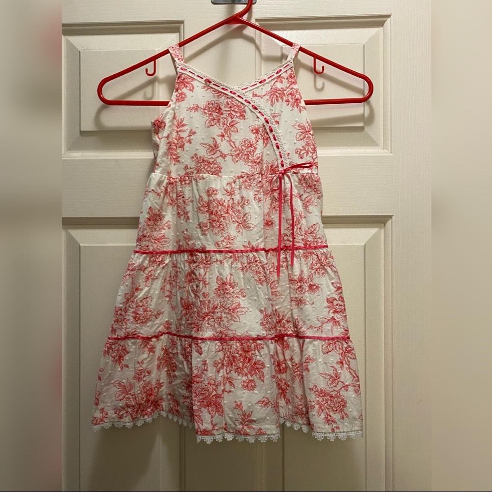 White sundress with bright pink flower pattern.